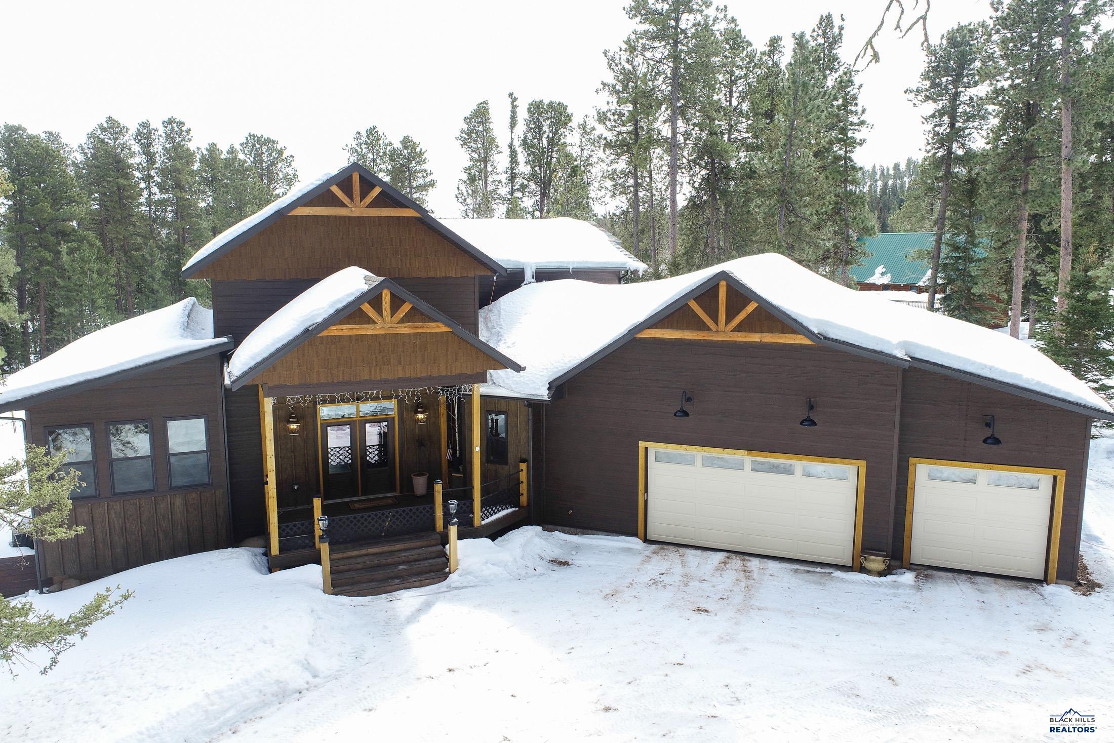 Listed by Michael Warwick 605-641-2569 & Heath Gran 605-209-2052 Great Peaks Realty. Boasting an array of stylish finishes and a thoughtful open plan layout, this immaculate 4 bedroom, 3 bathroom cabin located in the Deer Mountain subdivision is the dream getaway! The location is top-tier with being in a prime vacation rental area and minutes away from Historic Deadwood, Terry Peak Ski area, Mickelson Trail, and many other hiking/snowmobling trails. Step inside and fall in love with the granite countertops, abundance of storage space and gorgeous backsplash in the main level kitchen, as well as the spacious living room overflowing with natural light heated by a beautiful gas log fireplace. Spend a nice evening soaking in the hot tub without having to step outside. In the early mornings you can appreciate nature by spending time on the amazing open deck with a nice, warm coffee.