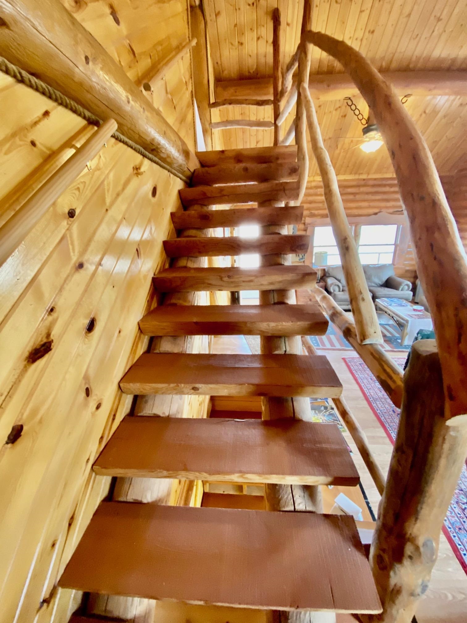 One of a kind hand crafted log stair well to second floor.