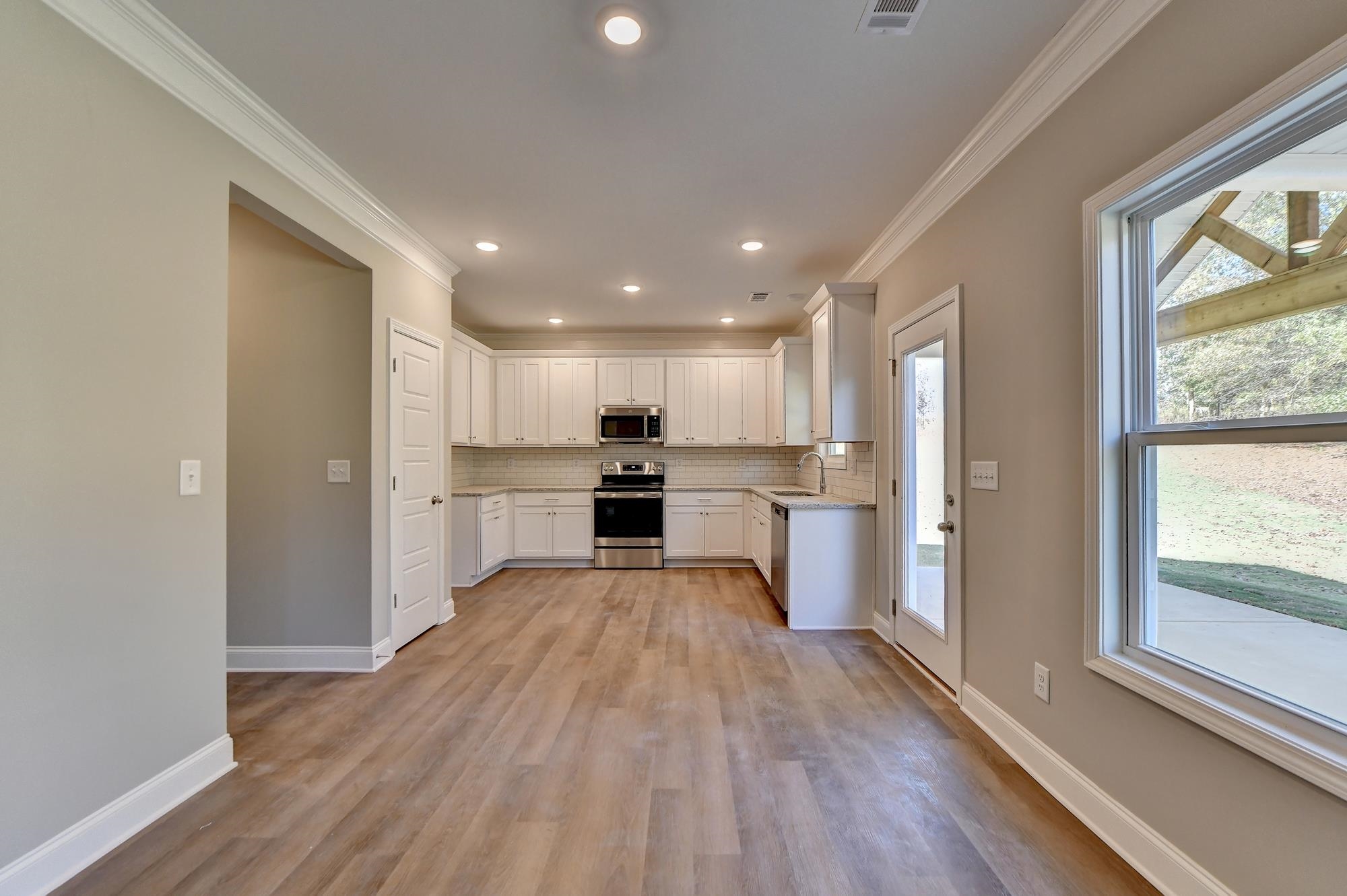 Kitchen with sink, crown molding, light hardwood / wood-style floors, stainless steel appliances, an