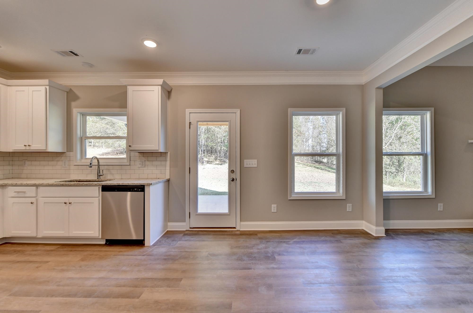 Kitchen with sink, crown molding, light hardwood / wood-style floors, stainless steel appliances, an