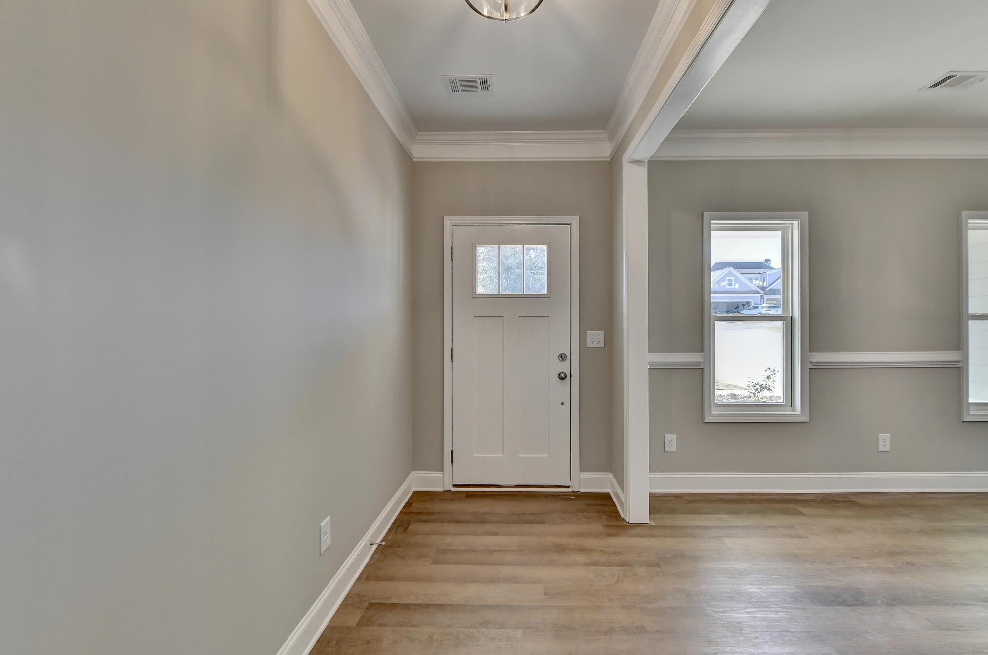 Foyer entrance featuring light hardwood / wood-style flooring and ornamental molding