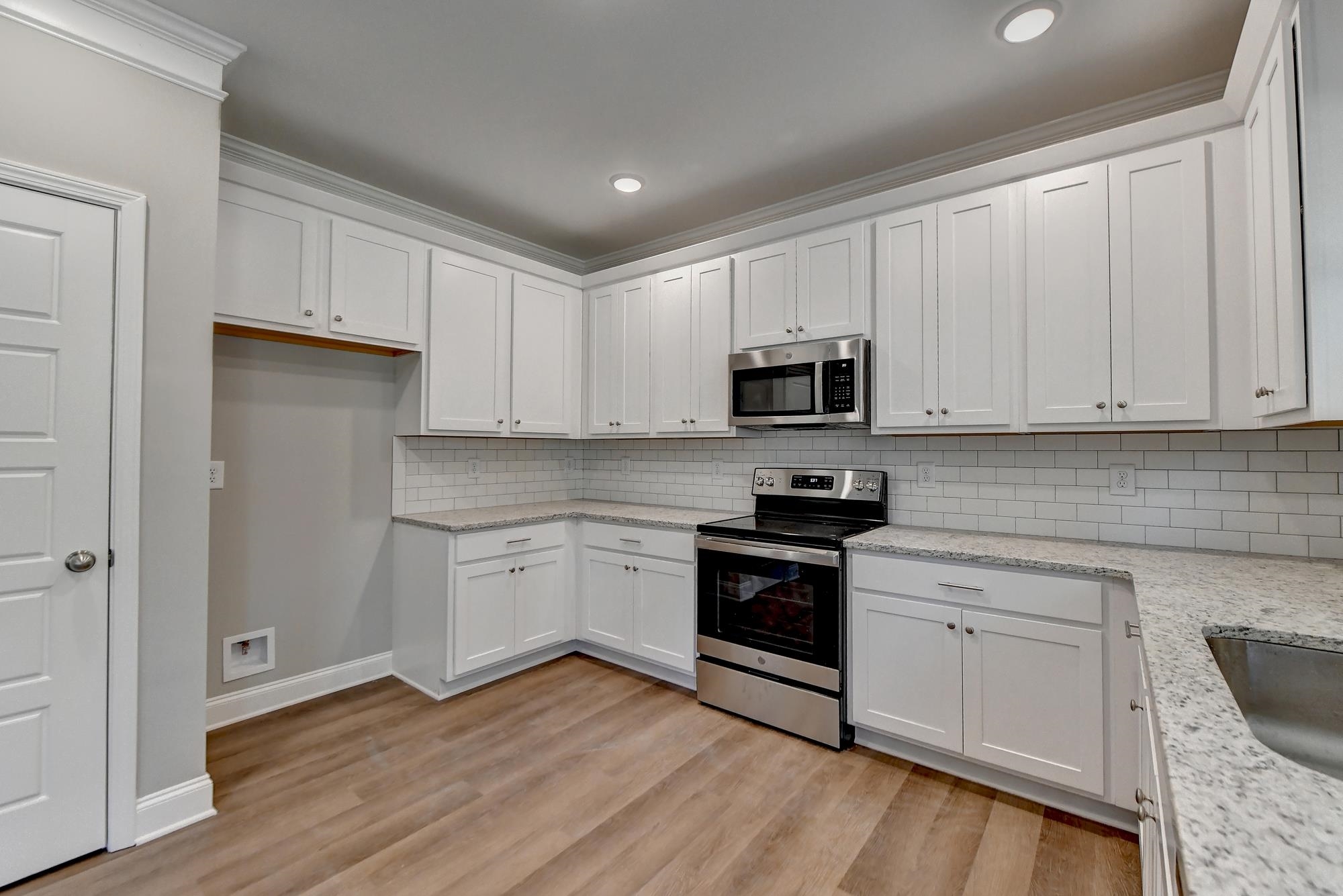 Kitchen with sink, crown molding, light hardwood / wood-style floors, stainless steel appliances, an
