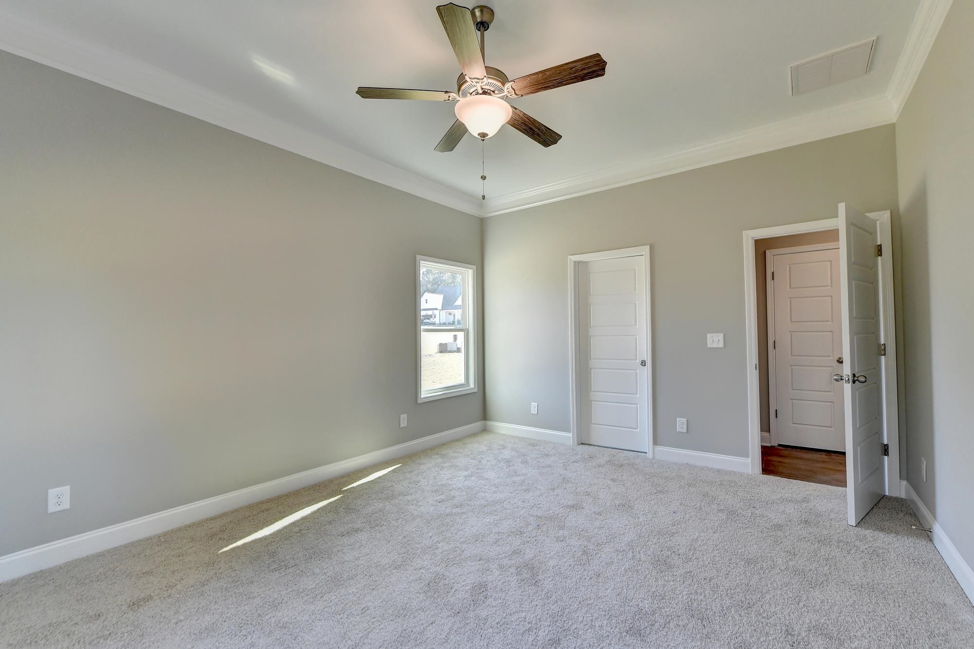 Master Bedroom featuring ceiling fan, ornamental molding, and light carpet