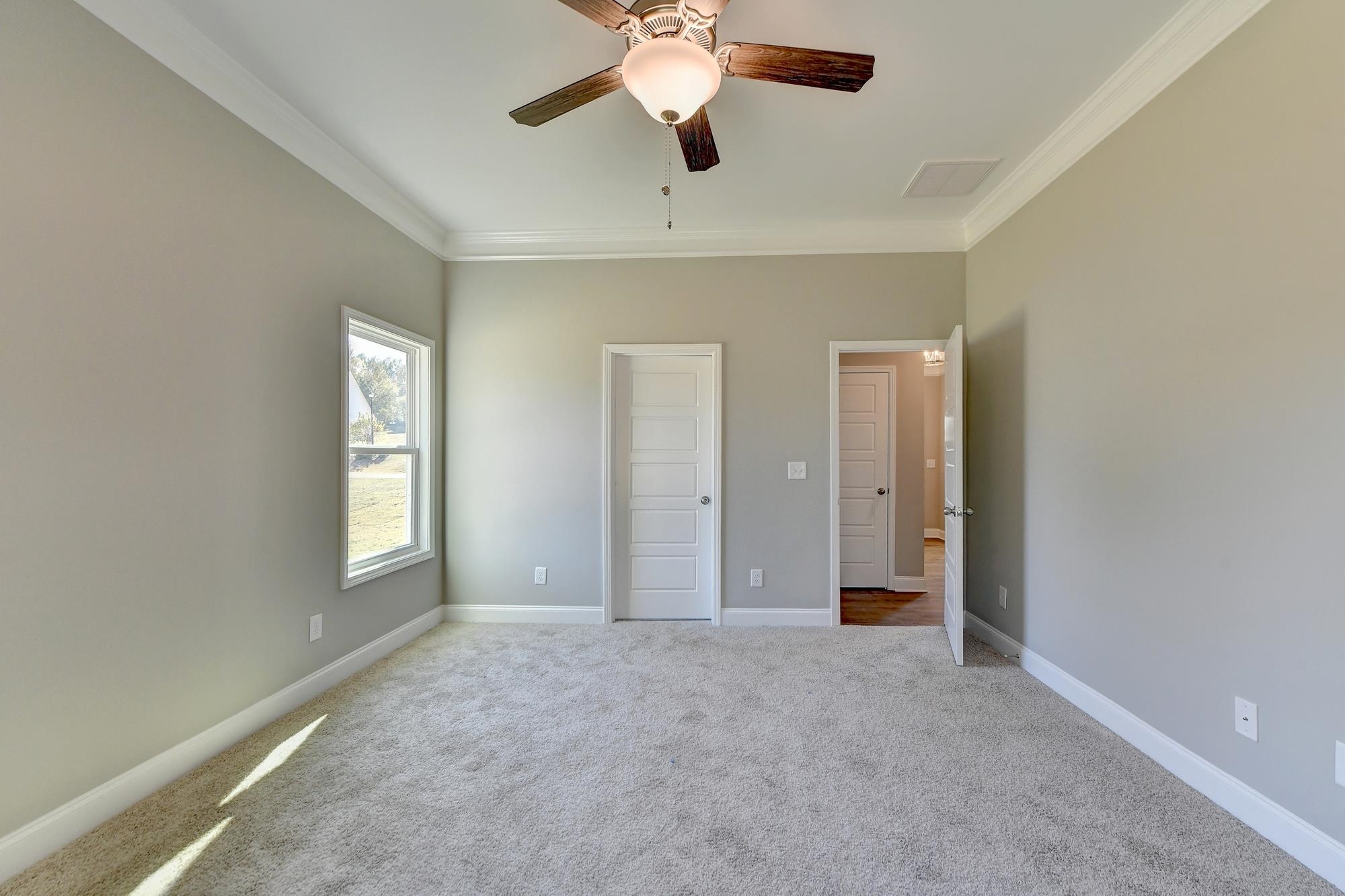 Master Bedroom featuring ceiling fan, ornamental molding, and light carpet