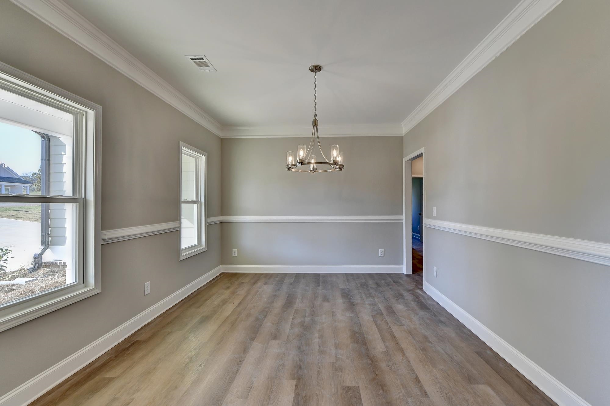 Dining room with an inviting chandelier, dark hardwood / wood-style floors, and crown molding