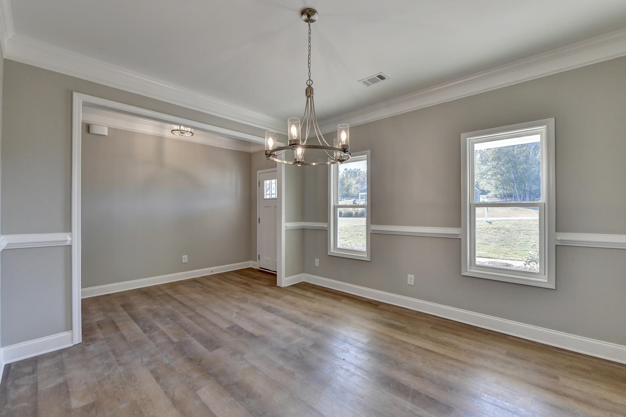 Dining room with an inviting chandelier, dark hardwood / wood-style floors, and crown molding