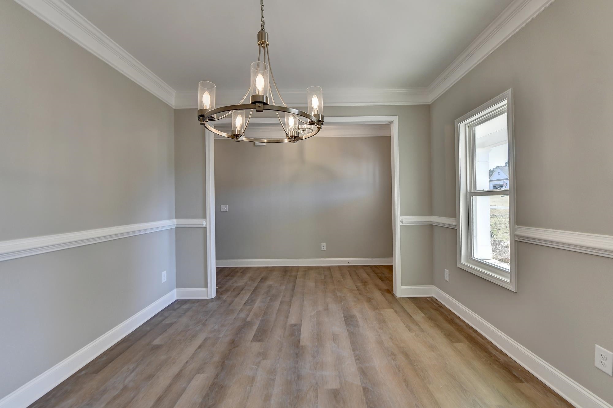 Dining room with an inviting chandelier, dark hardwood / wood-style floors, and crown molding