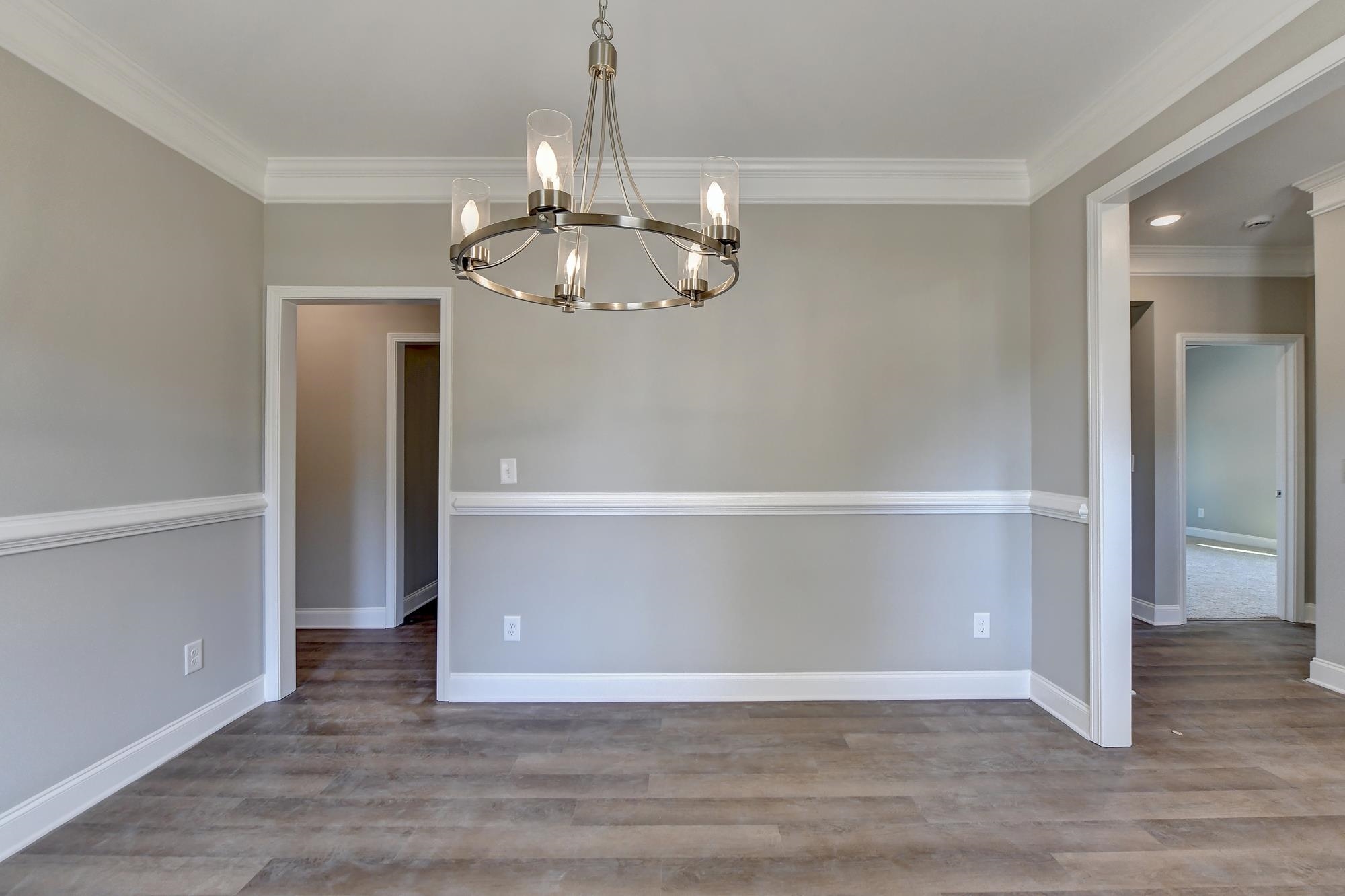 Dining room with an inviting chandelier, dark hardwood / wood-style floors, and crown molding