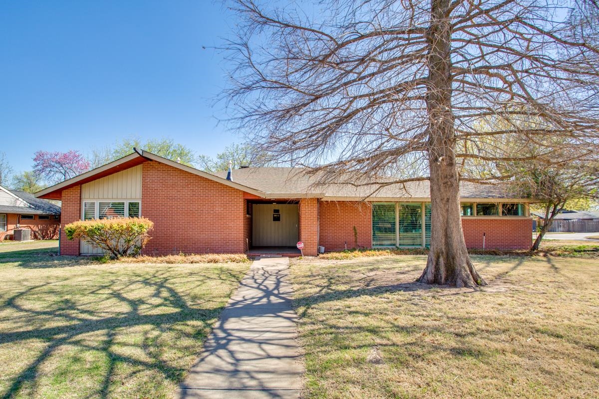 This mid century modern home wows you the minute you walk in. With 3 bedrooms, 2 1/2 baths and 2 living areas that abound with natural light. The home has a wonderful mix of updates and original features. Outside you will find a large backyard (seller is offering a $1500 landscape allowance) with mature trees and large storage building. Don't miss this one of a kind home in the Indian Hills Addition.