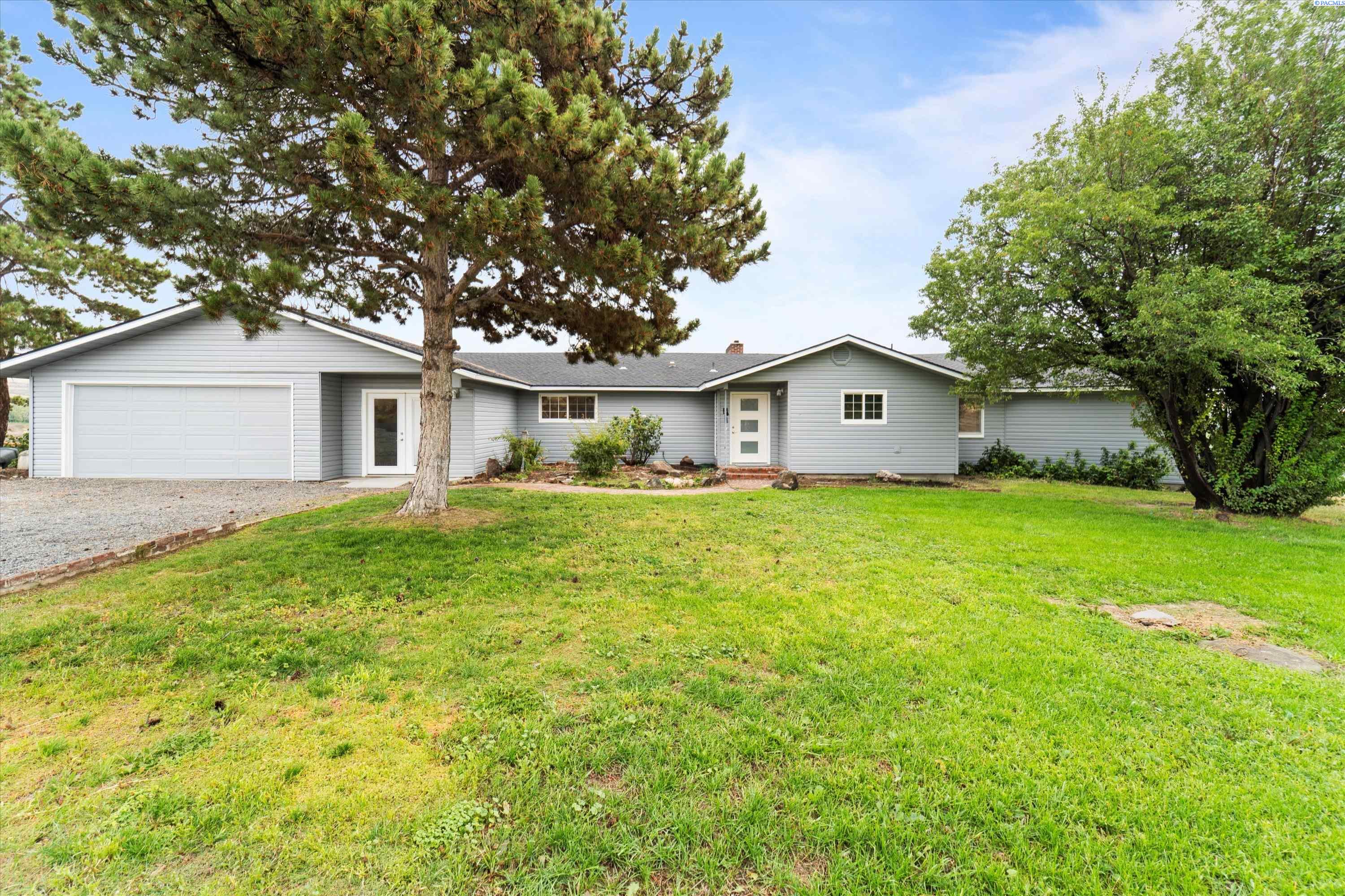 MLS # 271458 A peaceful county property near Moxee, WA.  With four bedrooms, four bathrooms, and an array of features that provide ample space for everyone. The main level showcases a beautiful great room with a fireplace and vaulted ceiling, creating a cozy and inviting atmosphere. The formal dining area and a spacious kitchen with new appliances, countertops, and backsplash offer a perfect setting for gatherings and meals. The main level also includes a master bedroom with its own bathroom and walk-in closet, providing a private retreat with access to a new deck and a stunning view. Additionally, there are three guest bedrooms, each with its own bathroom. A versatile flex room can be used for various purposes like a workout room, craft room, or playroom, allowing for customization based on your needs. The property has been updated with new flooring, exterior doors, electrical systems, and fresh paint both inside and out, providing a modern and refreshed look. Two new decks provide ideal spots to relax and enjoy the scenic views. The new well pump ensures a reliable water supply. The lower level offers a family room, bathroom, and an additional bedroom, adding to the flexibility and potential of the property. With endless possibilities, this property seems like a great place for comfortable living and creating lasting memories with family and friends.