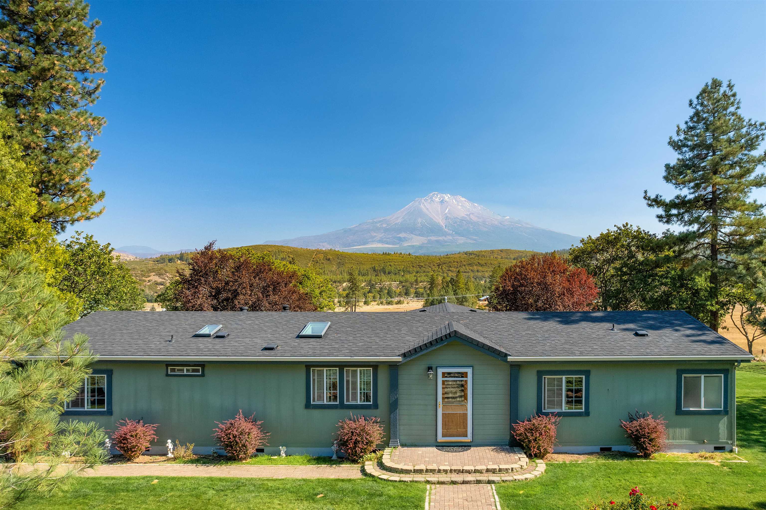 This property has it all, beautiful views of Mt. Shasta & Black Butte. Surrounded by a beautiful, landscaped yard with an underground sprinkler system & shade trees. China Ditch runs through the property with water rights, a pond, field for grazing livestock & a horse shelter. This property sits on over 12 acres with a mix of trees & open spaces. Step into the bright & welcoming move in ready home, that is over 2000 sq ft. The open concept offers a family rm & living rm, open dining area & a large kitchen with stainless steel appliances & granite countertops. The home offers 4 bedrooms & 2 bathrooms. New carpet in all the bedrooms & living area with fresh interior paint in most of the home. Brand new roof & freshly painted deck. Step onto the back deck & entertain your guests under the large gazebo, & soak in all the natural beauty, & wildlife. Paved parking area, large pad cleared for extra parking or ready to be built on. The home has a backup generator, RV parking with hookups. Shed for extra storage & a huge 2000 sq ft shop 40’x50’. With 3 roll up doors. Shop is completely insulated, has a backup generator, heating, & bathroom. Wired with multiple 220 plugs that are 60amp.