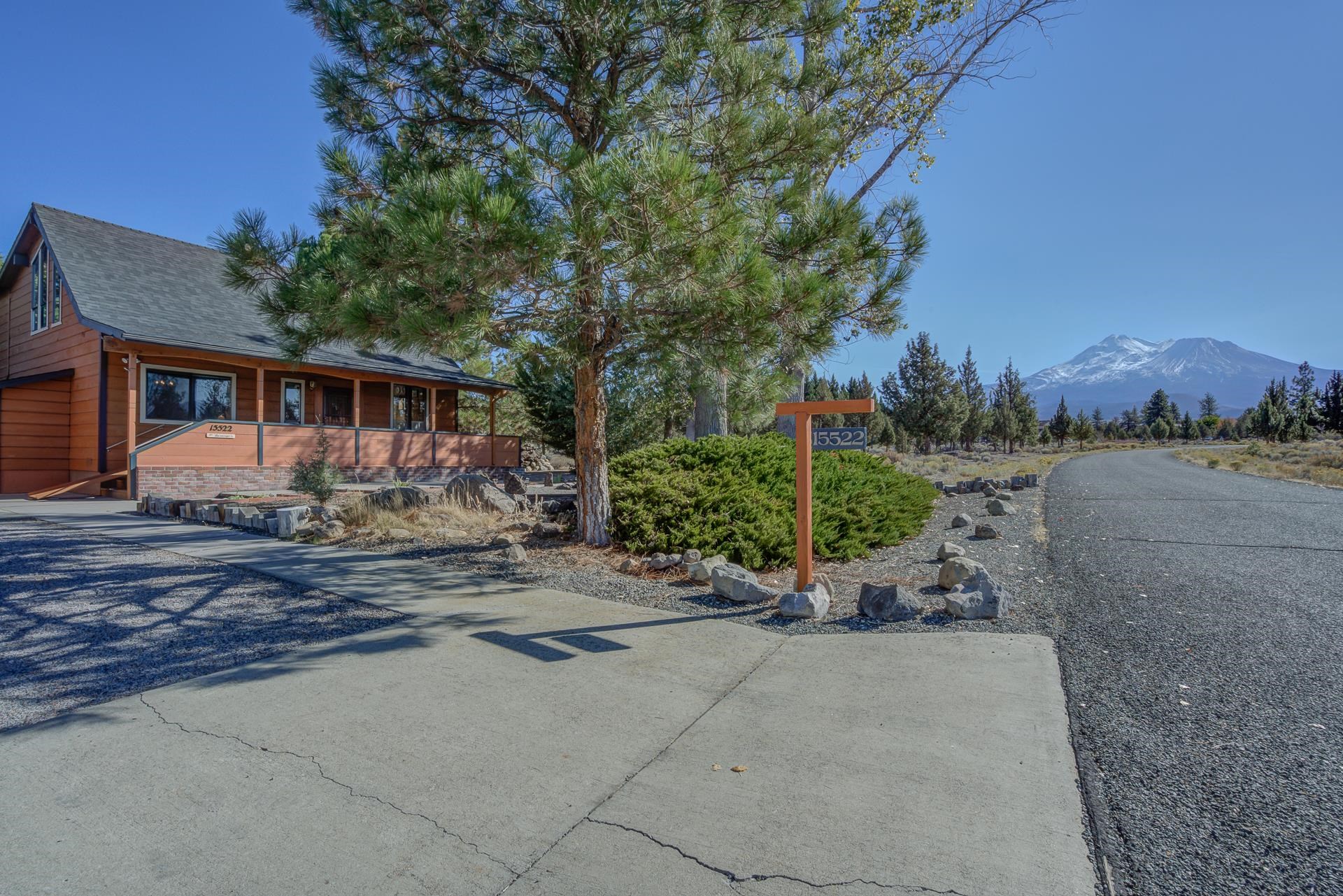 This beautiful craftsman style home has many elements traditionally found in a log cabin. Lots of windows make it bright with a view of Mt Shasta. The Livingroom has a corner pellet stove and vaulted ceilings that open into the library upstairs. Kitchen has an ample amount of counter space, a small breakfast bar, large walk-through pantry leading to an enclosed sun porch that overlooks the back yard. First floor oversized master bedroom has a large walk-in closet, seating area and private entrance. The second downstairs bedroom is currently being used as a den with large windows that face Sherwood. Great room is located upstairs with the third bedroom, walk-in closet and second full bathroom. The unique library/reading nook is cozy with a balcony that overlooks the first floor. Homeowner thoughtfully equipped the staircase with a chairlift to aide his spouse with access to the second floor. The landscaping was designed to fit the area and contains many water features. This MUST-SEE listing reflects the love and devotion this couple had for their home.