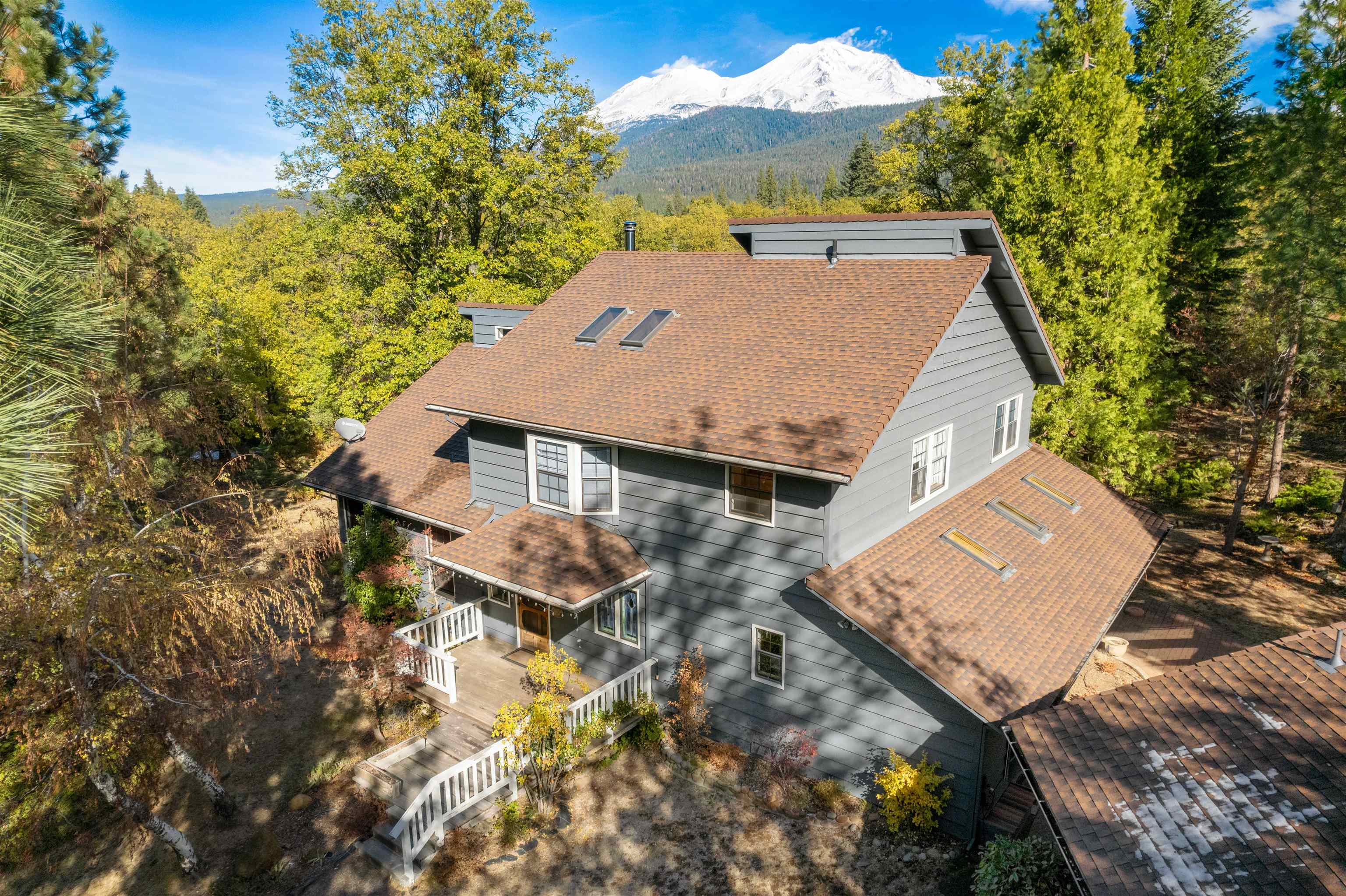 House located in a very desirable Mt. Shasta location offering privacy and seclusion.  This beautiful home features an open floor plan, vaulted pine ceilings with large wood beams, amazing picture windows with fabulous view of Mt. Shasta, cozy river rock hearth,  and lovely hardwood floors.  The home sports a 4 seasons room with lots of windows, sky lights, tile floor, sink with tile counter and French doors.  The master bedroom features vaulted wood ceilings, and French doors leading to the view filled living room.  The master bath offers stone flooring and a tile shower enclosure with a view of Mt. Shasta. The second floor of the home has a comfortable family room with a window seat, vaulted wood ceilings with sky lights and a full bath with tile counter tops.   The house features wood trim, built in cabinetry and wood closet doors throughout the house.  The garage features a workshop with wood stove and lots of natural light.  The property offers a front porch, large back deck facing Mt. Shasta and plenty of room for gardening!