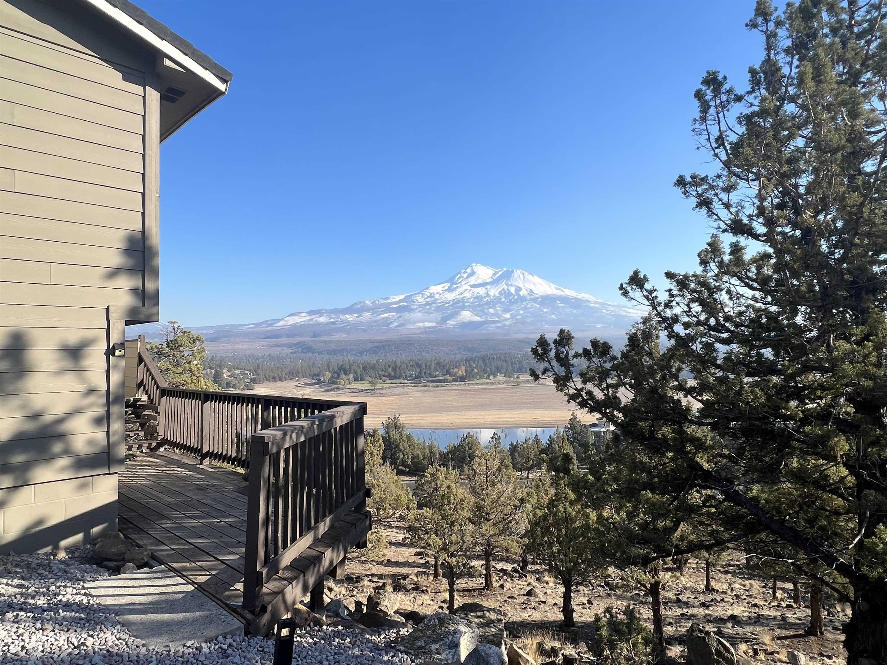 Breathtaking Mt. Shasta views from this contemporary mountain home! A split-foyer welcomes you into the bright home, highlighted by large picture windows and new flooring throughout. Mountain views from 3 bedrooms. A full bathroom on each of the 2 levels makes for a functional layout. The wrap-around deck has 180 degree views of Mt. Shasta, Black Butte, the Eddy's, and Lake Shastina. A small but useable garden with new artificial turf and space for additional outdoor seating has been added in the past year. Plenty of indoor storage. A quick 5 minute drive to Lake Shastina Golf Course and restaurant. Enjoy the quaint nearby town of Mt. Shasta and all the lakes, skiing, waterfalls, and hikes in the area. An hour to Ashland, OR and an easy drive to the Medford airport. Home was previously a vacation property, lots of opportunity! Nestled into a peaceful neighborhood with acres of land between homes and private boat launch access to Lake Shastina. Option to purchase partially-furnished. Imagine sipping your morning coffee while taking in the epic views!