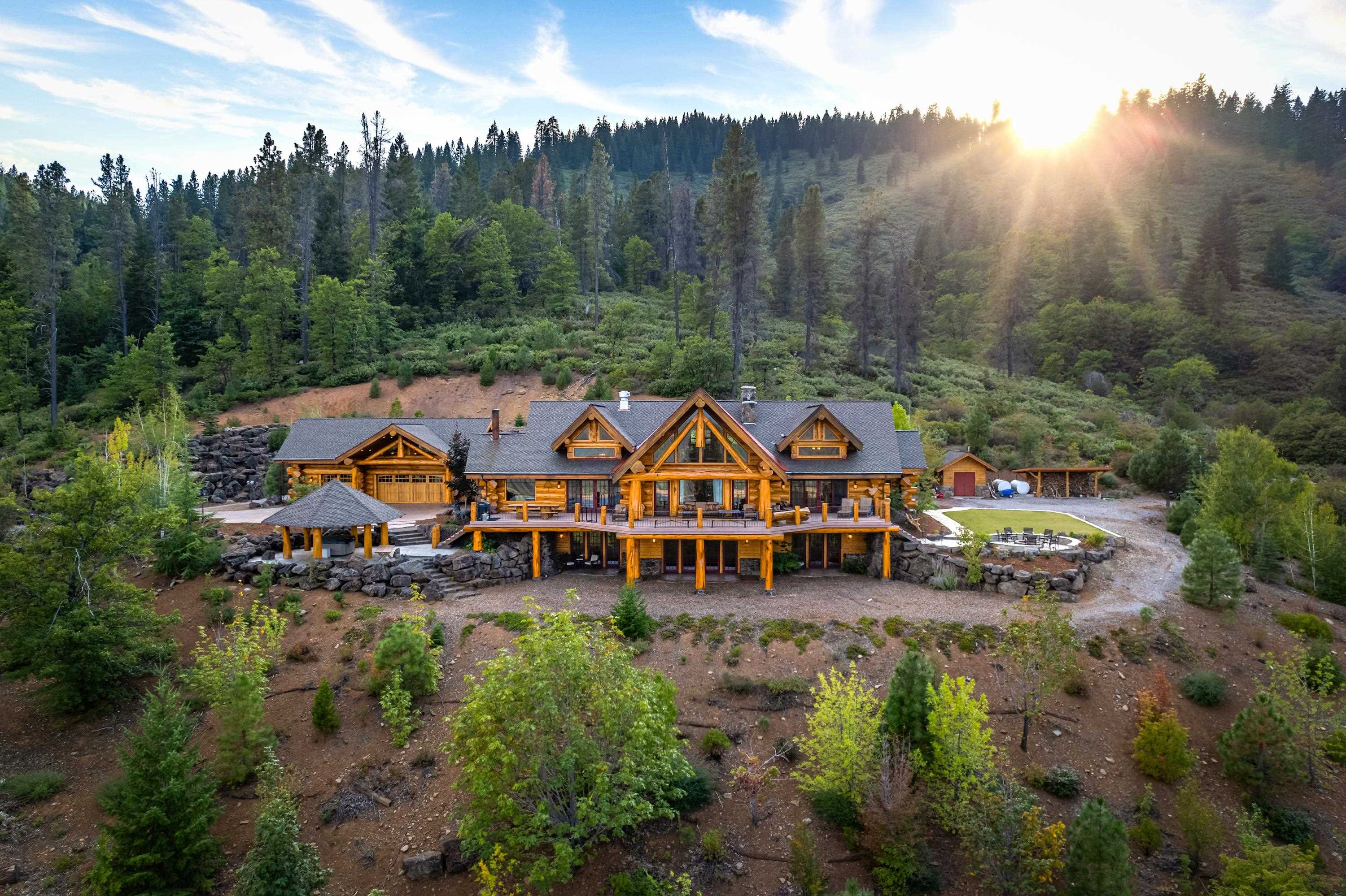 Perched at 4,000 ft. elevation in the midst of pines, oaks, and dogwoods, encompassing 55 acres with commanding views of majestic Mt. Shasta and picturesque Lake Siskiyou you will discover, Sentinel Retreat. Located just 10 minutes from downtown Mt. Shasta, this remarkable estate presents an exceptional opportunity to own a custom-built luxury Pioneer Log Home. Boasting an expansive 7,600 square feet of living space and 1,000 square feet of guest quarters above the garage, coupled with a 1,700 square foot outdoor deck, this log home offers a harmonious blend of rustic elegance and mountain casual luxury. With three levels, four spacious bedrooms, three full bathrooms, and one-half bath, there is ample room to accommodate family, friends, and guests. There is a great deal of craftsmanship to be seen throughout the home. Whether it’s the meticulously hand-carved mighty eagle above the front door or the wooden bears climbing the 20-foot “feature tree” that greets you as you enter Sentinel Retreat, no details are spared. No matter the season, right outside your front door or just a short drive away, outdoor recreation abounds - hiking, biking, climbing, swimming, canoeing, & kayaking.