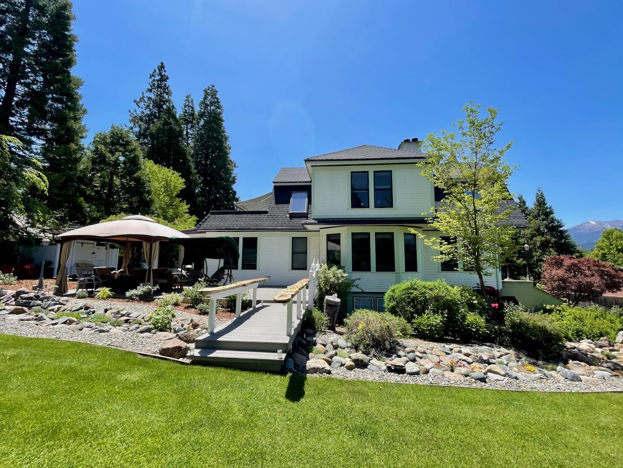 Gorgeous Mt Shasta views from this one-of-a-kind estate on .43 ACRES, end of cul-de-sac with walk to town, schools & parks location! Original Edson Home completely rebuilt in 1991. Three stories, 6 BED & 5 1/2 BTH, each floor with its own kitchen / kitchenette, water heater & separate electric meters.  Ensuite bathroom & fireplace in many of the bedrooms. The views from the home are spectacular w/ large wood cased dual pane vinyl windows, radiating light, views of Black Butte & Mt Shasta! Interior staircases with rich wood banisters flow to each floor, Brazilian cherry wood floors, newer carpeting, large kitchen island, newer roof &  heat pumps / AC. Many versatile spaces, yoga / meditation room, laundry room & exterior office ~ easily work from home.  Stunning outdoor paradise; terraces / decking, professionally landscaped manicured lawns, shrubs, flora, roses, Japanese Maples, and even a dry creek  fairy garden!  Upstairs has balcony patio with awning & Trex decking and stairway leading to the outdoor fun; jacuzzi, sauna & gazebo.  Most furnishings & existing Bed and Breakfast business & supplies are included in the purchase.  Check with Mt Shasta City for future uses.