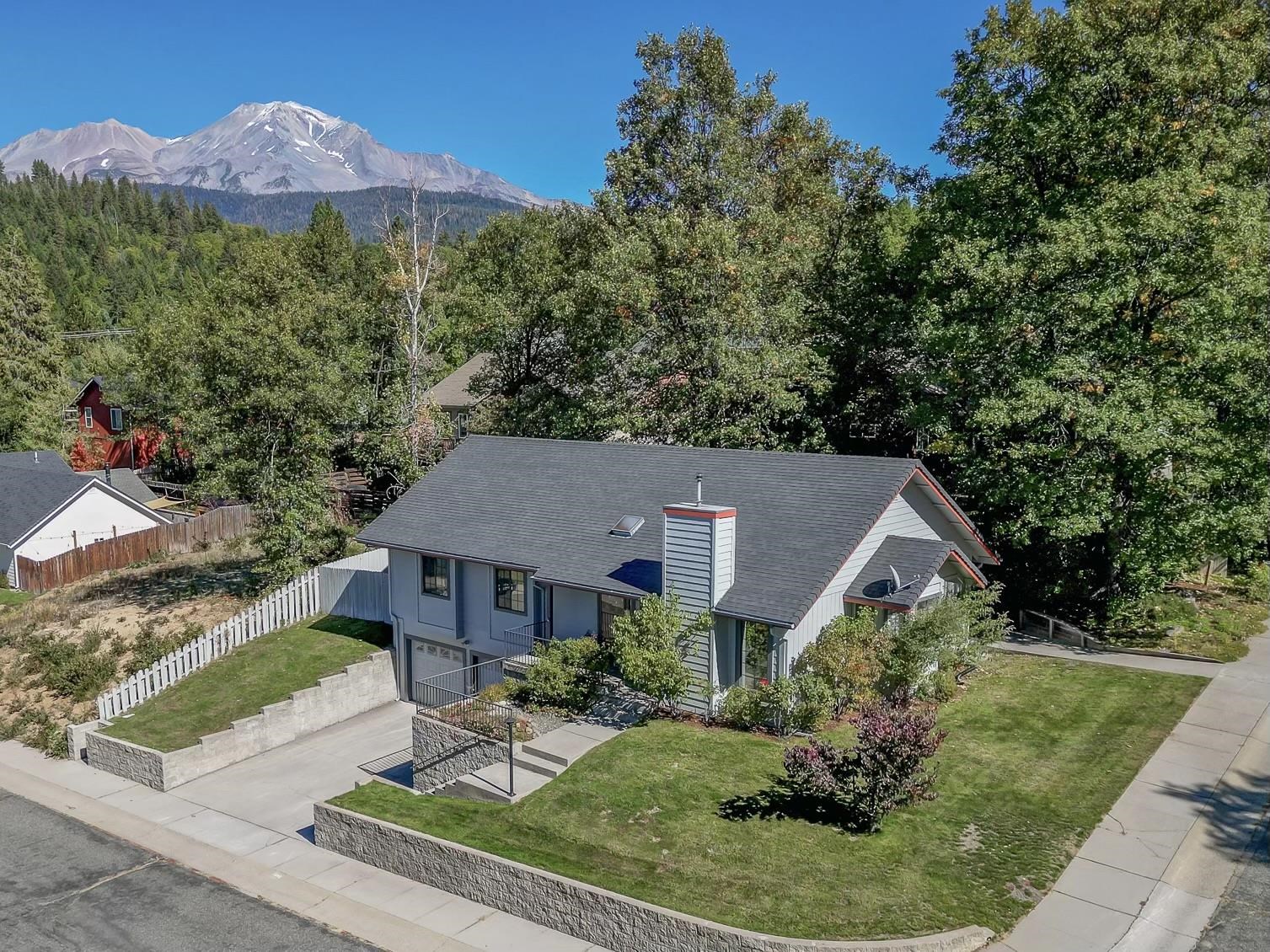 Pride of ownership is evident in this immaculate 1,676/+658 sq ft, 3 bed & 3 full bath Mt. Shasta home. Enter the living room with vaulted ceilings, gorgeous Ravelli pellet stove (with brick surround), skylight, ceiling fan & bay window. The spacious dining room with sliding glass door to outside patio + small deck is wonderful for entertaining. The charming bright eat-in kitchen features new flooring, oak cabinets, dishwasher, refrigerator, microwave, electric range, built in desk & garbage disposal. A beautiful Master Suite includes a walk-in closet, ceiling fan, attached bathroom with walk-in shower and sliding doors with access to the back patio. The 658 sq ft downstairs basement gives you the opportunity for ample storage which could easily be converted into more living space with laundry & full bathroom. The yard is easily maintained with perennials, trees & landscaping. F/A propane heat & AC. Bonus items: Generac home generator, sprinkler system, security system, dumbwaiter for pellet stove & oversized 2 car garage. Fabulous Mt. Eddy view & peek-a-boo views of Mt. Shasta & Black Butte improve in winter. Enjoy all Mt Shasta has to offer in this corner lot move-in-ready home!