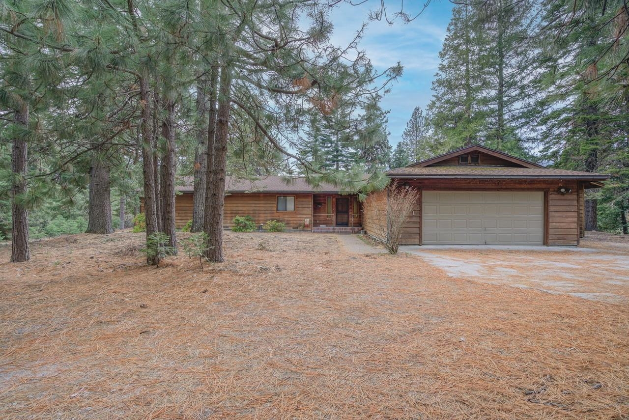 NESTLED IN THE TREES is where you will find this lovely 2180sqft, 4 bedroom, 2 bath home that is ready for you to make it your own. The home is situated on 2.40 country acres. There is a true sense of privacy and mountain living while being close to town. Interior features include a woodstove, wood accented ceilings in the living room, built-in book shelves, 4 separate slider doors opening up to the deck (2 in the living area, 1 in the dining area & 1 in the primary bedroom), a dedicated laundry room, nicely sized bedrooms with large closets, an eat at kitchen bar as well as dining room. From the wrap around back deck you are hugged by your own private forest.  Schedule a private showing today before this one is snapped up!