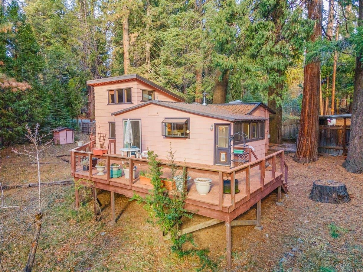CHARMING MT SHASTA HOME with 2bd/1ba and 1014 sq ft of cozy living space! Crafted with custom woodwork throughout, this home offers a unique blend of comfort and character. Step into the kitchen adorned with custom cabinetry, featuring a built-in desk and a delightful garden window overlooking the backyard. The warmth of a wood stove, complemented by monitor and electric baseboard heat, ensures flexible and efficient heating options for year-round comfort. The spacious deck in back provides ample outdoor space for entertaining guests or simply unwinding amidst serene surroundings. A light & airy loft is situated above the main bedroom—currently used as a yoga room but easily adaptable to your needs, whether as an office, playroom, art studio, or therapy space. The converted garage, now a versatile workshop/storage room, could be restored to its original function with the addition of a door. Other features include a metal roof, vaulted ceilings, skylights, and a basement/root cellar. Situated conveniently close to town and freeway access to the ski park and beyond, this home is an ideal choice for those seeking a starter, vacation, or downsizing retreat. SCHEDULE A TOUR TODAY!
