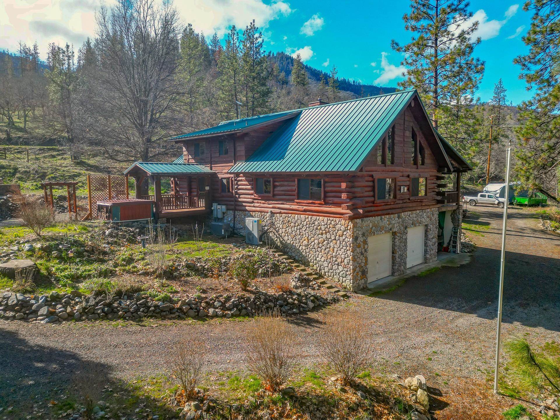 An opportunity you have dreamed about...A custom 5BR 3BA true log home, overlooking an expansive, lush green lawn that transitions to 630+/- feet of prime river frontage. Uniquely placed at the end of the county maintained road, privacy is the order of the day. Whether launching your boat to fish or raft from your private low bank frontage, or, hiking and ATV'ing the hundreds of miles of trails/roads on the thousands of acres of Klamath National Forest out of your gate..."BORED" will never be a word you will hear your family speak. Relax from the days adventures in the 8 person hot tub, or from the 50x12 covered porch facing the rapids. The home has been tastefully upgraded with new flooring, central heat & A/C, oversized 2 person jacuzzi tub, 20' rock fireplace, and much more! Invite friends to visit, 2 full RV hookups & 1 with electricity only. Fruit trees, raised garden beds, back up generator, Starlink Internet  and DSL available.