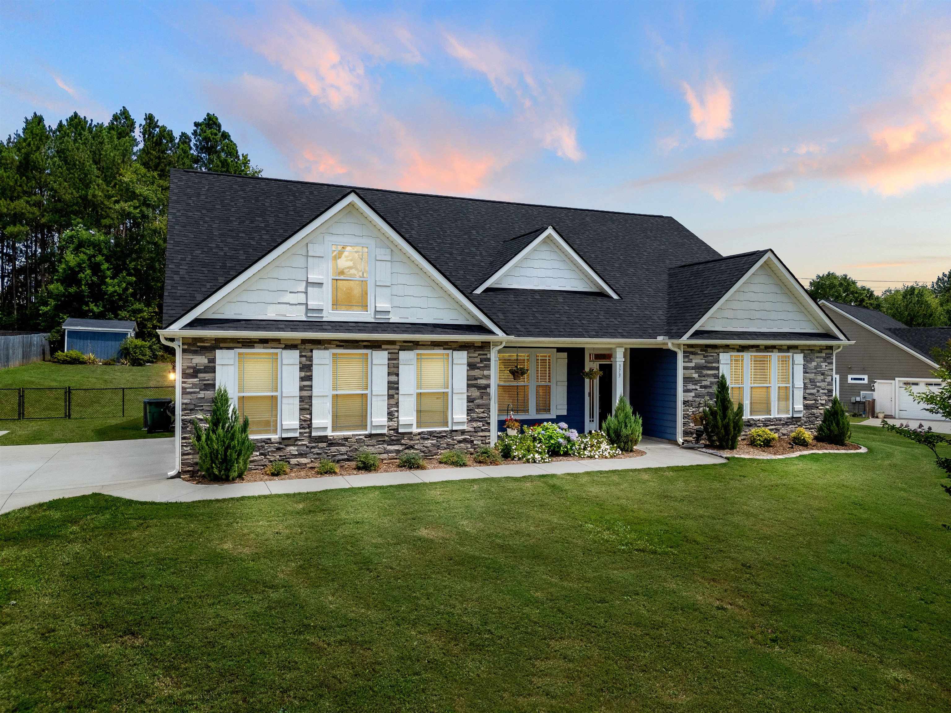 Welcome to 373 Roy Hall Way — a stunning 2020-built home in the sought-after Cane Creek Subdivision, just minutes from Landrum High School. This beautifully designed property features a Hardie board exterior, side-entry garage, fenced backyard, and a spacious outbuilding for additional storage or workspace.  Step inside to find extensive trim work, tray ceilings, and thoughtfully designed spaces throughout. The home offers a formal dining room, cozy living room with propane gas logs, and a dedicated office with built-in bench seating and shelving. The kitchen includes white cabinetry, granite countertops, and recently updated white appliances. The laundry room is both functional and stylish, featuring upper cabinets, a utility sink, and extra storage.  Enjoy peaceful mornings on the inviting front porch and unwind on the screened back porch overlooking the backyard. The primary suite includes a spa-like tiled shower with dual shower heads.  Community amenities include a playground, walking trails, and a neighborhood pond with a dock — offering a perfect blend of comfort and outdoor living in a quiet Campobello setting.