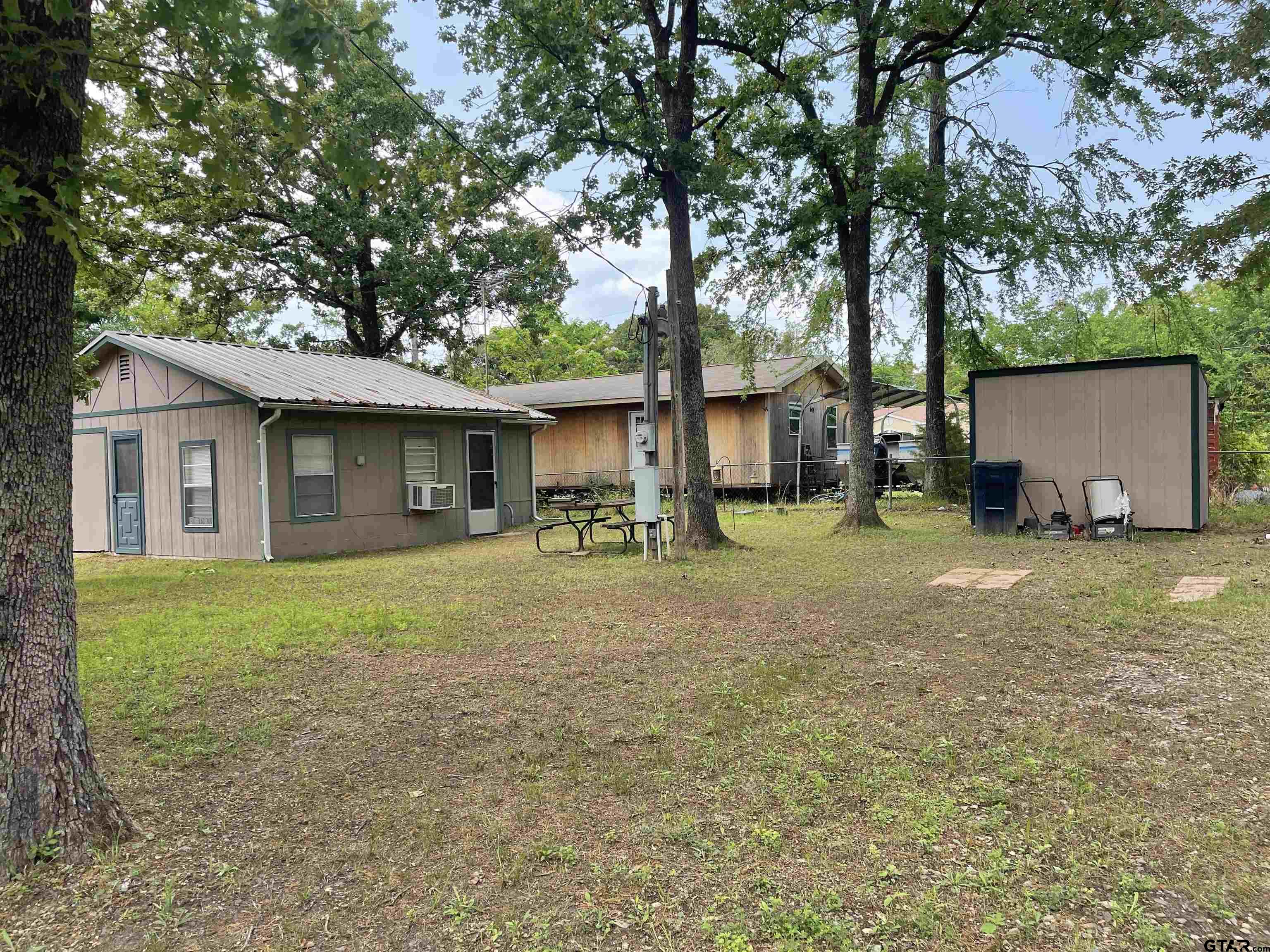Located in the Lake Fork waterfront community of Steamboat Shores. This is a cozy cottage on 3 fully fenced lots. The cottage features a cozy kitchenette and living-sleeping area. The bathroom are is large and in midst of remodel which the buyer will need to complete. There is a golf cart garage attached to the cottage and an additional storage shed. Steamboat Shores features it’s own private fishing ramp and dock for homeowners, as well as community pool and clubhouse.