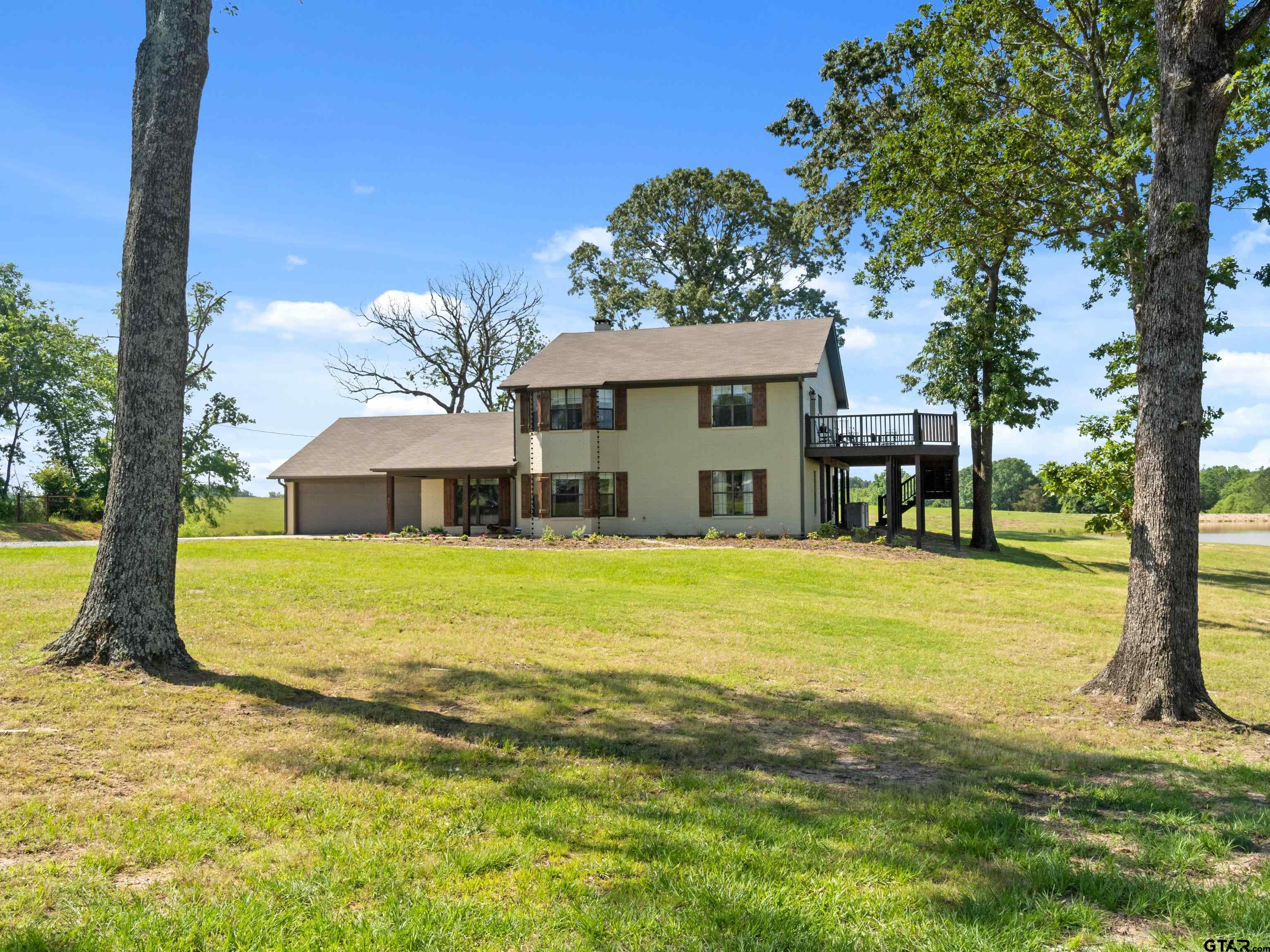 This Upshur County beauty pulls out all of the stops. Almost 5000 sq ft including decks overlooking almost 40 acres with 2ponds covering 7 acres! Sit on the deck and enjoy the breeze, drop a line into the stocked ponds, work the cattle in the pipefence pens or start a project in the 6000+/- sq ft shop that is fully insulated with living quarters and 2 project rooms. Thepossibilities are endless and that's just the outside! Inside the home, you will find all updated floors, countertops, appliances,bathrooms and refreshed paint! This 5 bedroom, 3 bath house provides plenty of space to spread out and storage galore! Ifyou need an office space, it's here! And it overlooks the back ponds. Don't want to share your closet? No problem! This mastersuite has 2 big, separate walk-in closets. But can we talk about the master bath? Relax in your soaker tub while you overlookyour land. Enjoy the view while your trouble melt away. OR find yourself invigorated after a shower in this multiheaded tiledshower. Watch the sunrise or the sunset on the deck off of the master bedroom. Work or play, this ranch has it all.